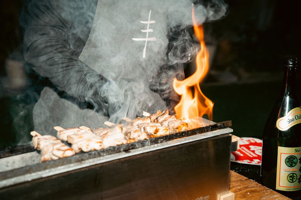 Yakitori grilling over flame and smoke